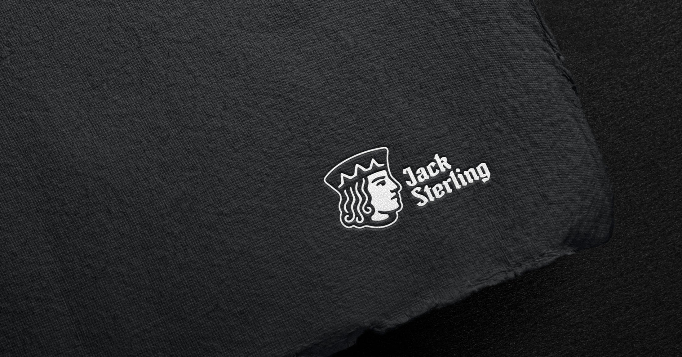Jack Sterling logo featuring a crowned head profile and wordmark, printed on dark textured paper