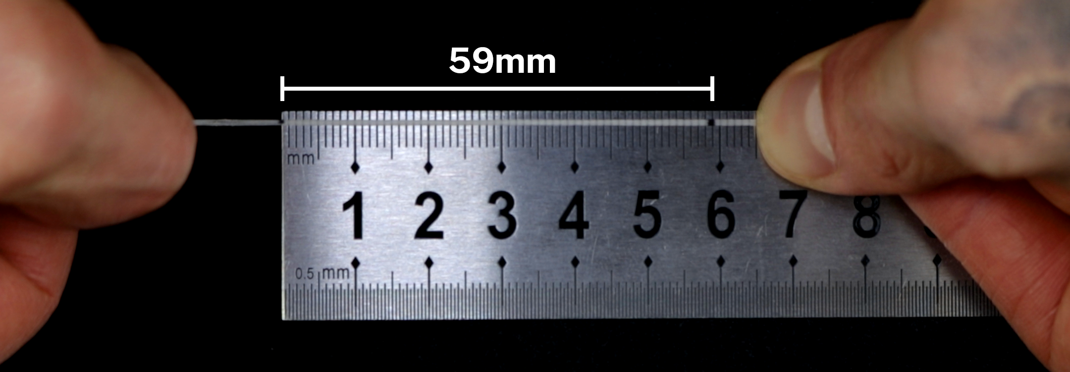 Measuring a length of string against a ruler to determine ring size in millimetres, Jack Sterling ring sizing guide